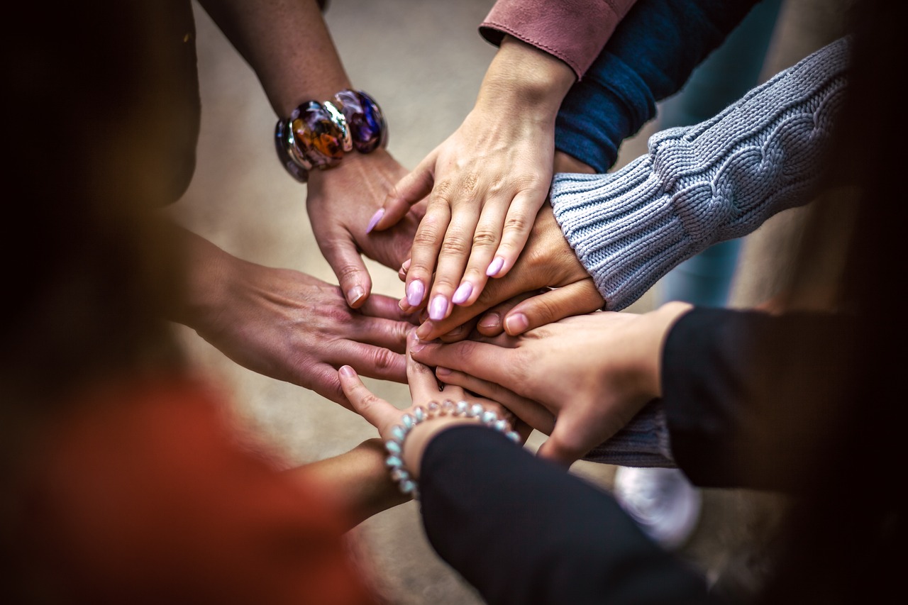 Hands together, Norm's Roofing gives and promotes their community in Northern Michigan