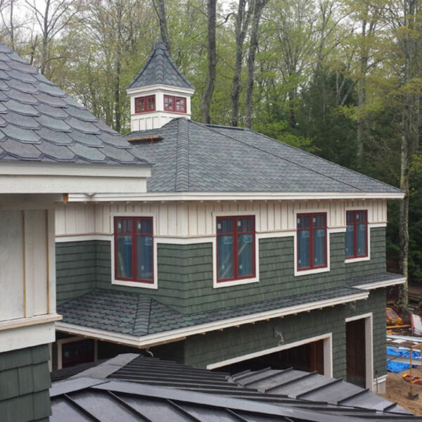 Beautiful cedar shake exterior lake house with asphalt shingles, installed by expert roofers at Norm's Roofing
